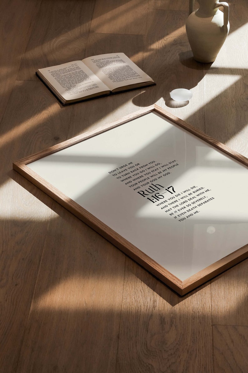 May include: A framed print with a white background and black text. The text is a quote from the Bible, Ruth 1:16-17, which reads: "Don't urge me to leave you or to turn back from you. Where you go I will go, and where you stay I will stay. Your people will be my people and your God my God. Where you die I will die, and there I will be buried. May the Lord deal with me, be it ever so severely, if even death separates you and me."