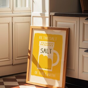 May include: A framed print with a yellow background and a white salt shaker illustration. The text reads "Be the salt, Salt, Matthew 5:13, Of the Earth."