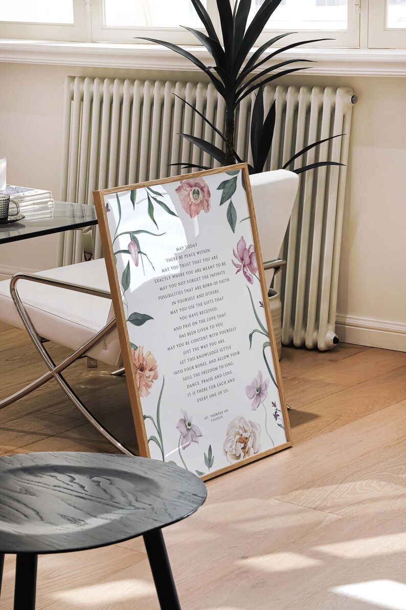 May include: A framed print with a white background and floral illustrations. The print features a quote about peace and trust, with the text "WAY TODAY THERE BE PEACE WITHIN MAY YOU TRUST THAT YOU ARE EXACTLY WHERE YOU ARE MEANT TO BE MAY YOU NOT FORGET THE INFINITE POSSIBILITIES THAT ARE BORN OF FAITH IN YOURSELF AND OTHERS MAY YOU USE THE GIFTS THAT YOU HAVE RECEIVED AND PASS ON THE LOVE THAT HAS BEEN GIVEN TO YOU MAY YOU BE CONTENT WITH YOURSELF JUST THE WAY YOU ARE LET THIS KNOWLEDGE SETTLE INTO YOUR BONES AND ALLOW YOUR SOUL THE FREEDOM TO SING DANCE PRAISE AND LOVE IT IS THERE FOR EACH AND EVERY ONE OF US ST. THOMAS ON LOVE"