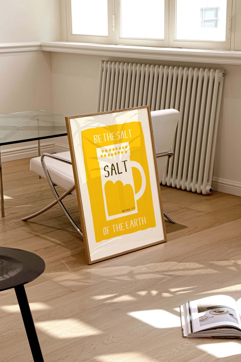 May include: A yellow framed poster with the text "Be the salt" and a white illustration of a salt shaker with the word "SALT" on it. The text "Matthew 5:13" and "of the earth" are also on the poster.