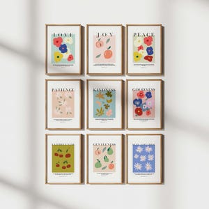 Puede incluir: Nueve l&aacute;minas enmarcadas con ilustraciones bot&aacute;nicas y palabras inspiradoras como "Amor", "Alegr&iacute;a" y "Paz". Cada l&aacute;mina presenta una paleta de colores y un dise&ntilde;o diferentes, incluyendo flores, frutas y formas abstractas. Los marcos son de madera natural.