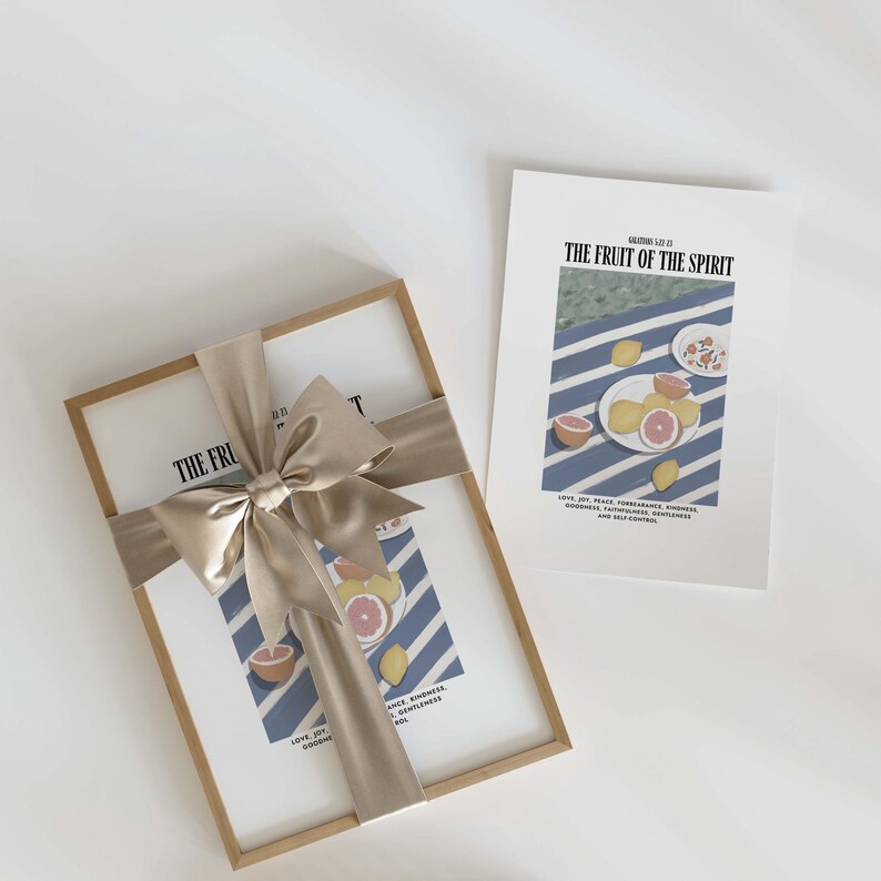 K&ouml;nnte beinhalten: Ein gerahmter Druck mit einem blau-wei&szlig; gestreiften Hintergrund und einer Schale mit Zitronen und Orangen. Der Druck tr&auml;gt den Text "The Fruit of the Spirit" und eine Liste von Eigenschaften: "Love, Joy, Peace, Patience, Kindness, Goodness, Faithfulness, Gentleness, and Self-Control".
