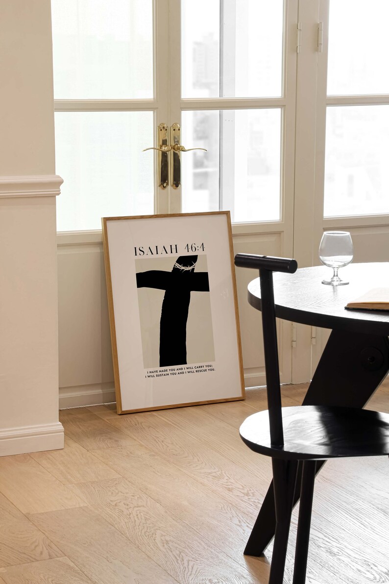 May include: A framed print with a black and white illustration of a cross with a crown of thorns. The text "ISAIAH 46:4" is at the top of the print. The text below the illustration reads "I have made you and I will carry you. I will sustain you and I will rescue you."