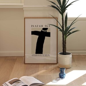 May include: A framed print with a black and white illustration of a cross with a crown of thorns. The print has the text "ISAIAH 46:4" and the quote "I have made you and I will carry you. I will sustain you and I will rescue you."