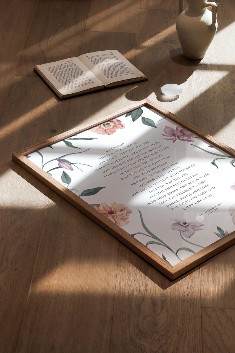 May include: A framed print with a white background and floral illustrations. The print features a quote about peace, trust, and faith. The quote reads: "May today there be peace within. May you trust that you are exactly where you are meant to be. May you not forget the infinite possibilities that are born of faith in yourself and others. May you use the gifts that you have received. And pass on the love that has been given to you. May you be content with yourself. Just the way you are. Let this knowledge settle into your bones, and allow your soul the freedom to sing, dance, praise and love. It is there for each and every one of us. - T. Therese of Lisieux"