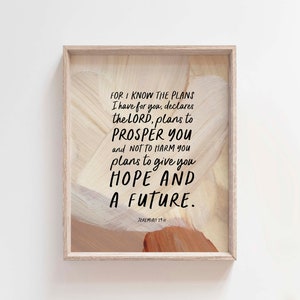 May include: A framed print with a woodgrain background and a white painted heart shape. The print features a bible verse from Jeremiah 29:11, "For I know the plans I have for you, declares the LORD, plans to prosper you and not to harm you, plans to give you hope and a future."