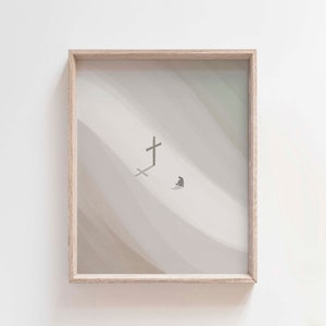 Puede incluir: Una impresión enmarcada con un diseño minimalista que presenta una cruz y una pequeña figura en una gama de colores beige y gris apagados.