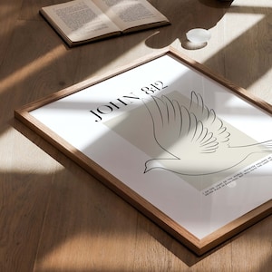 May include: A framed print with a white background and a black line drawing of a dove. The text "JOHN 8:12" is in black at the top of the print. The quote "I am the light of the world. Whoever follows me will never walk in darkness, but will have the light of life." is in black at the bottom of the print.
