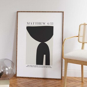 Pu&ograve; includere: Una stampa incorniciata con un design astratto in bianco e nero e il testo "MATTHEW 6:33" e la citazione "SEEK FIRST HIS KINGDOM AND HIS RIGHTEOUSNESS. AND ALL THESE THINGS WILL BE GIVEN TO YOU AS WELL."