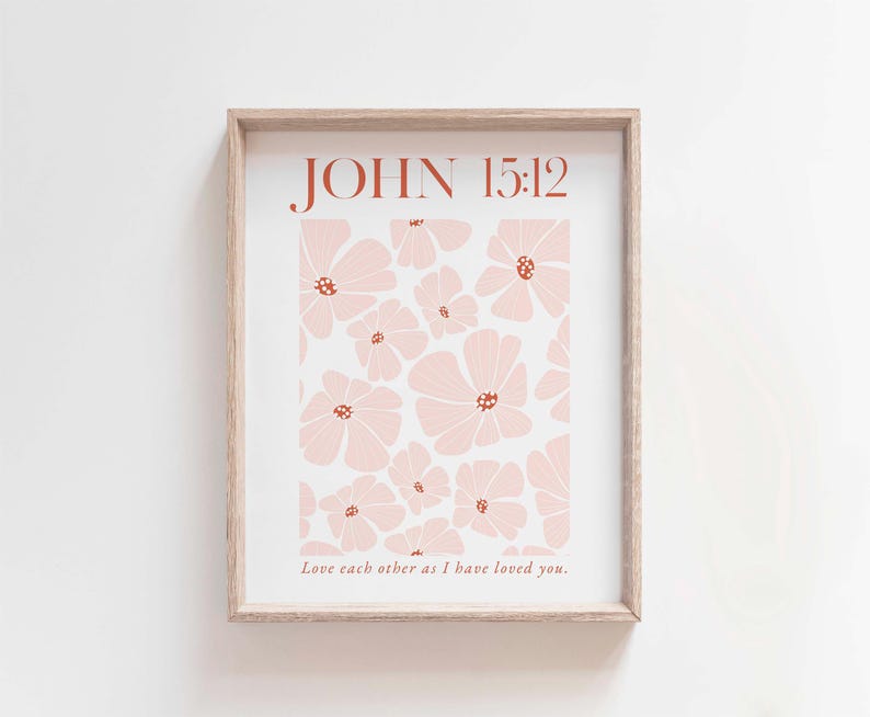May include: A framed print with a floral pattern in shades of pink and brown. The print features the text "JOHN 15:12" and the quote "Love each other as I have loved you."