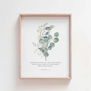 May include: A framed print with a watercolor illustration of eucalyptus leaves and a quote from Proverbs 31:31: "Honor her for all that her hands have done, and let her works bring her praise."