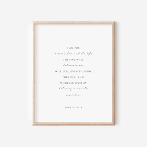 May include: A printable wall art print with a white background and black text. The text reads "I am the resurrection and the life. The one who believes in me will live, even though they die. And whoever lives by believing in me will never die. John 11:25-26"