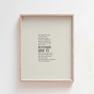 Pu&ograve; includere: Stampa incorniciata con sfondo verde chiaro e cornice in legno. La stampa presenta il testo "Geremia 29:11-13" in un carattere elegante, insieme a una citazione. L'estetica generale &egrave; minimalista e moderna.