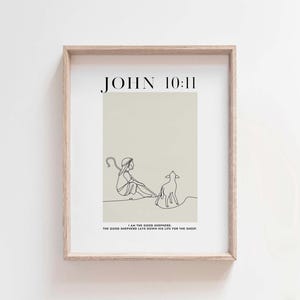 May include: A minimalist line art print with a beige background featuring a shepherd and a sheep. The print includes the text "JOHN 10:11" and the quote "I am the good shepherd. The good shepherd lays down his life for the sheep."