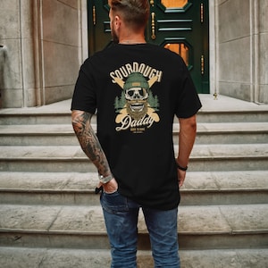 Man wearing black street wear graphic t shirt 90s aesthetic on the back showing sourdough bread french baguettes with smiling skull. baker shirt sourdough gift streetwear clothing for men. chef baking gifts christmas. Funny foody shirt