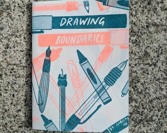 May include: A small, white booklet with a pink and teal design. The cover features the text "Drawing Boundaries" and illustrations of various drawing tools, including pens, pencils, and crayons.