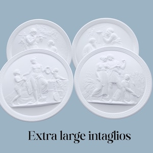 May include: Four white, circular intaglios with classical relief scenes. Each features figures in various poses, with detailed textures. The text "Extra large intaglios" is at the bottom. The background is a light blue.