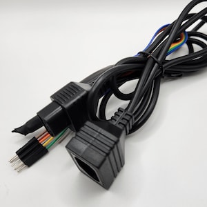 May include: Two black cables with connectors on each end. One connector has a multi-colored wire coming out of it. The other connector is a standard rectangular shape.