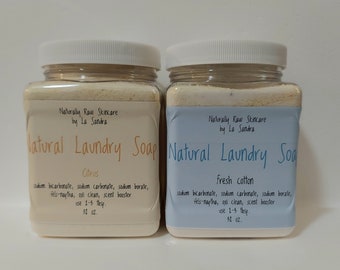 May include: Two clear plastic jars of natural laundry soap, one labeled "Citrus" and the other "Fresh Cotton". Both jars are labeled "Naturally Raw Skincare by La Sandra" and contain a white powder. Each jar contains 32 ounces of soap.