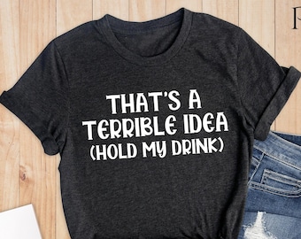 May include: Dark heather grey t-shirt with the text "That's a terrible idea (Hold my drink)" printed in white.