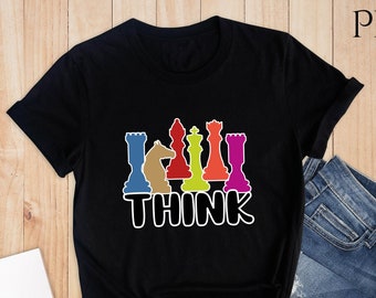 Può includere: Maglietta nera con una grafica di pezzi degli scacchi colorati e la parola "THINK" stampata sotto.