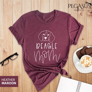 May include: Heather maroon t-shirt with a white outline of a beagle dog and the text "Beagle Mom" in white.