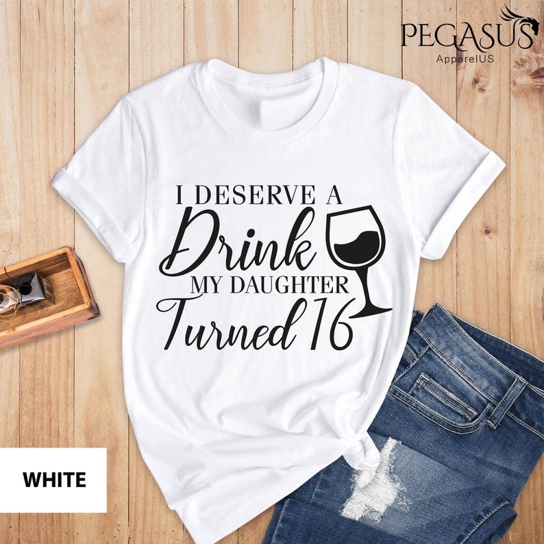 May include: White t-shirt with black text that reads "I deserve a drink my daughter turned 16" with a wine glass graphic.