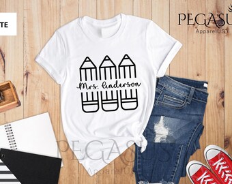 May include: White t-shirt with a black graphic of three pencils and the text "Mrs. Anderson".