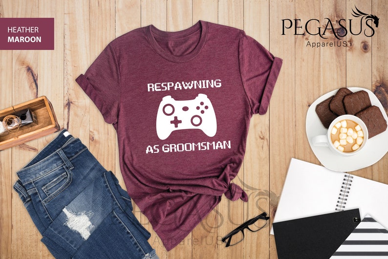 May include: Heather maroon t-shirt with a white graphic of a video game controller and the text "Respawning as groomsman".