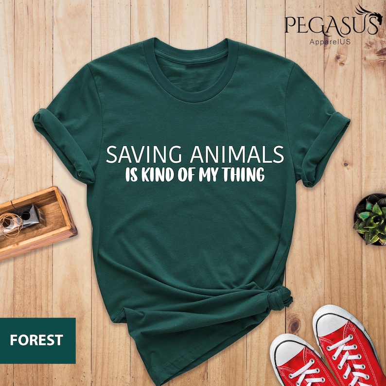 May include: A dark green t-shirt with the text "Saving Animals is Kind of My Thing" in white lettering.