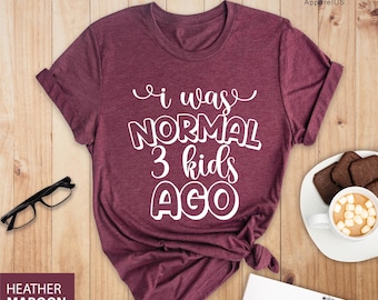 May include: A maroon t-shirt with white text that reads "i was NORMAL 3 kids AGO".