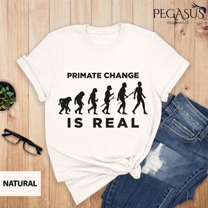 May include: White t-shirt with a black graphic of a primate evolution chain and the text "PRIMATE CHANGE IS REAL".