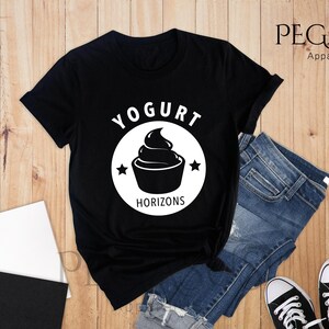 May include: Black t-shirt with a white graphic of a yogurt cup and the text "Yogurt Horizons".