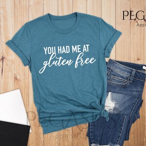 K&ouml;nnte beinhalten: Ein blaues T-Shirt mit dem Text "You had me at gluten free" in wei&szlig;en Buchstaben.