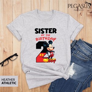 May include: Heather athletic gray t-shirt with the text "SISTER OF THE BIRTHDAY" and a graphic of Mickey Mouse. The number "2" is in black and red, with the word "BOY" at the bottom.