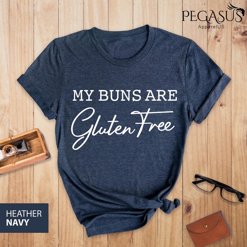 May include: A heather navy blue t-shirt with the text "My Buns Are Gluten Free" in white.