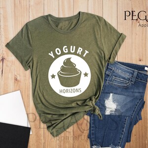 May include: A green t-shirt with a white circle design featuring a yogurt cup and the text "Yogurt Horizons".