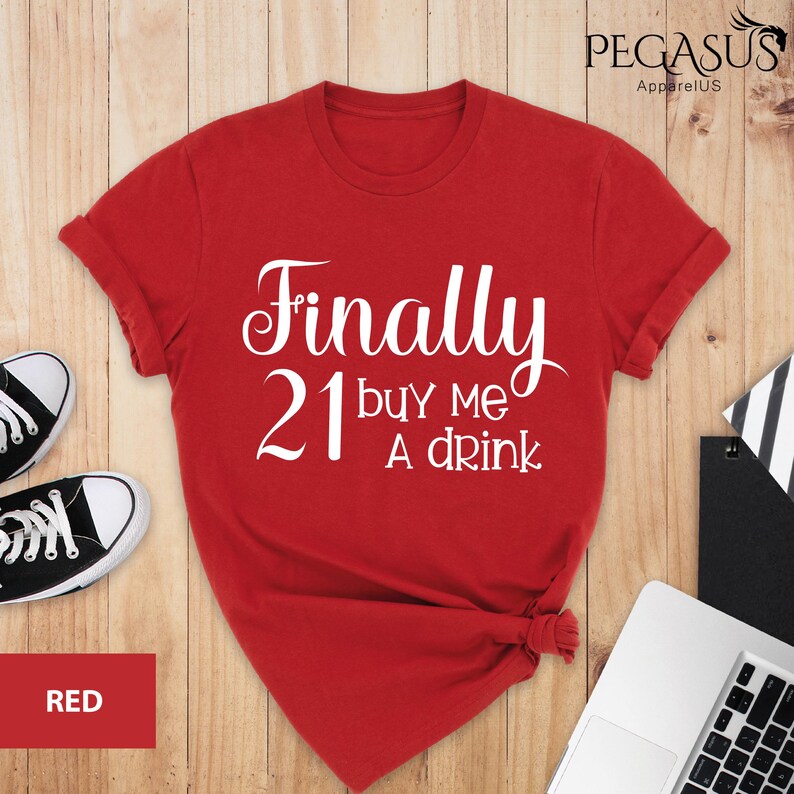 May include: Red t-shirt with white text that says "Finally 21 buy me a drink".