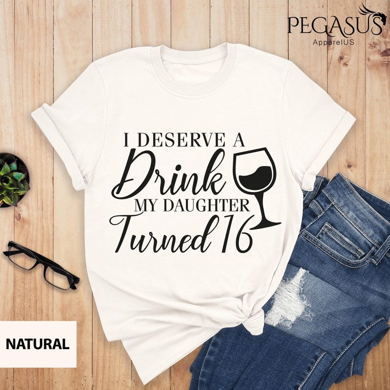 May include: White t-shirt with black text that reads "I deserve a drink my daughter turned 16" with a wine glass graphic.