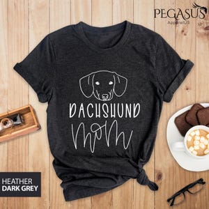 May include: Heather dark grey t-shirt with a white dachshund silhouette and the text "Dachshund Mom" in a cursive font.