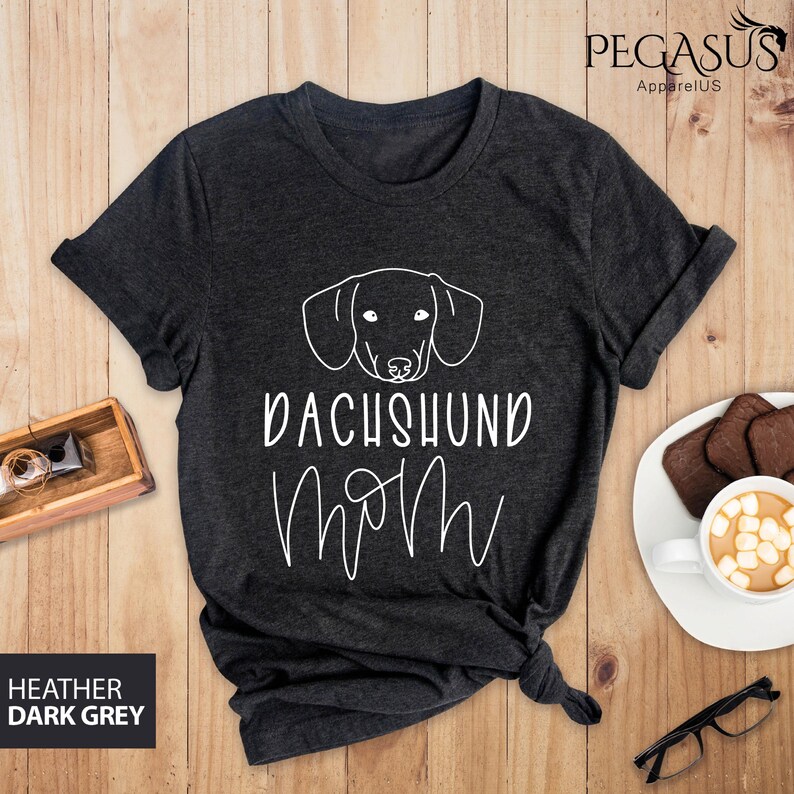 May include: Heather dark grey t-shirt with a white dachshund silhouette and the text "Dachshund Mom" in a cursive font.