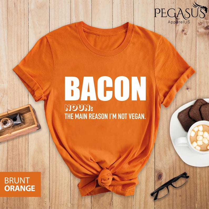 May include: Orange t-shirt with the text "BACON NOUN: THE MAIN REASON I'M NOT VEGAN." printed in white.