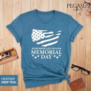 Peut inclure: Un t-shirt bleu avec un contour blanc du drapeau des &Eacute;tats-Unis et le texte "Remember and Honor Memorial Day" avec trois &eacute;toiles de chaque c&ocirc;t&eacute; du mot "Day".