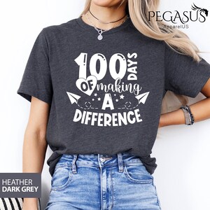 May include: Heather dark grey t-shirt with a white graphic that says "100 Days of Making a Difference".