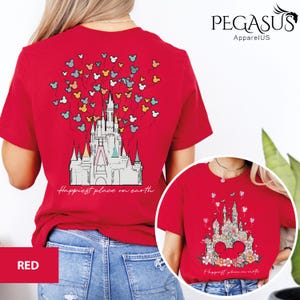 Op de afbeelding: Rood T-shirt met een afbeelding van Assepoester's kasteel en Mickey Mouse ballonnen. De tekst "Happiest place on earth" is onder het kasteel gedrukt.