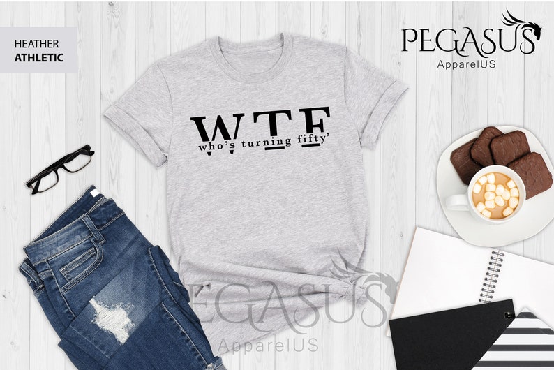 May include: Gray heather athletic t-shirt with black text that reads "WTF who's turning fifty".