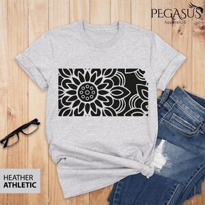 May include: A heather grey t-shirt with a black and white mandala design. The design is centered on the shirt and is a large, intricate pattern.