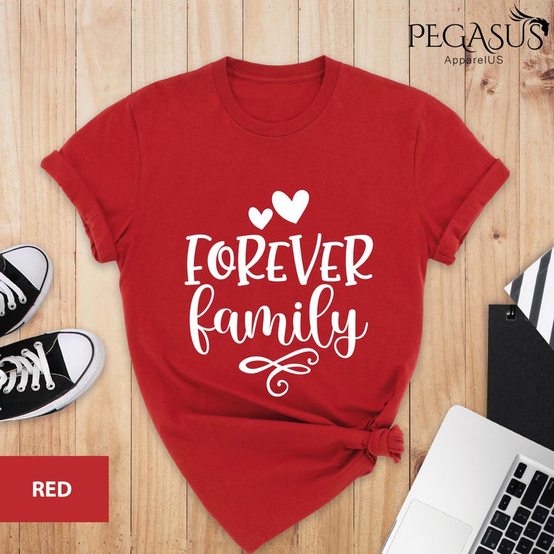 Pode incluir: Camiseta vermelha com texto branco que diz "FOREVER family" com dois cora&ccedil;&otilde;es pequenos e um cora&ccedil;&atilde;o maior acima do texto.