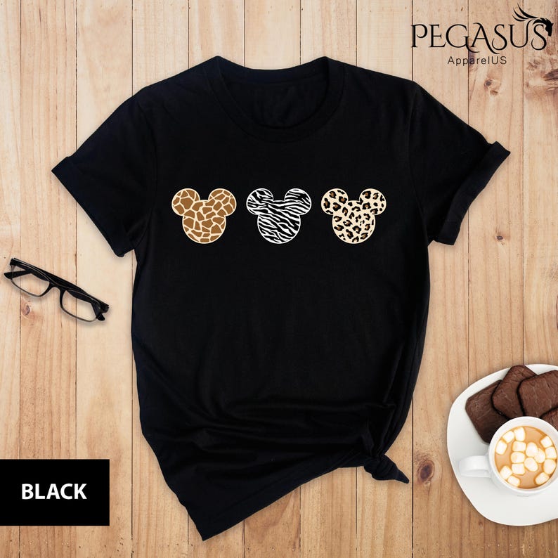 May include: Black t-shirt with three Mickey Mouse heads in different animal print designs: giraffe, zebra, and leopard.