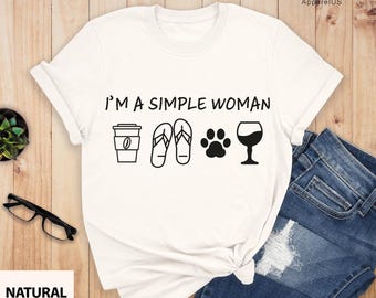 May include: White t-shirt with the text "I'm a simple woman" and icons of a coffee cup, flip flops, a paw print, and a glass of wine.